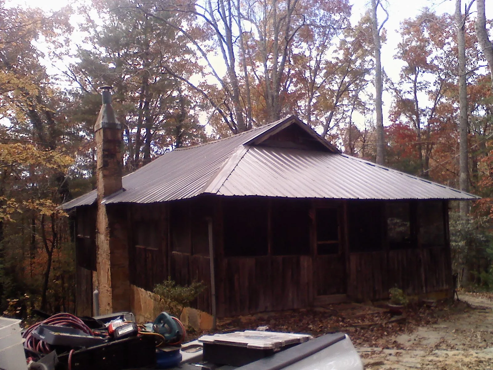 Brown metal hip roof on an old cabin with a stone chimney in Sonora
